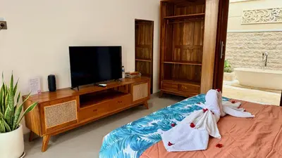 a living room with a tv and a couch at Emstaliese & Palmarosa Villas Seminyak in Legian