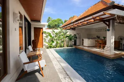 a house with a swimming pool next to a house at Emstaliese & Palmarosa Villas Seminyak in Legian