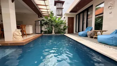 a swimming pool in the middle of a house at Emstaliese & Palmarosa Villas Seminyak in Legian