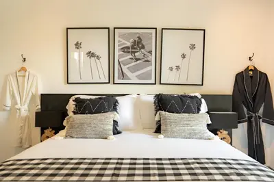 a bedroom with a bed and three pictures on the wall at Luxe Bali Seminyak Villa by Betterplace in Seminyak