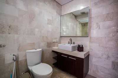a bathroom with a toilet and a sink and a mirror at Norm Villa Kuta in Kuta