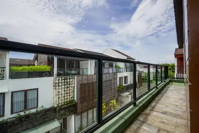an open balcony with a view of a building at Norm Villa Kuta in Kuta