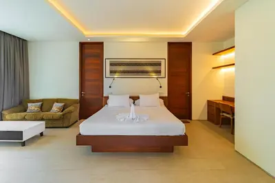 a hotel room with a bed and a couch at Luxury Rosa Village - 4 Bedrooms Walkable to Beach in Jimbaran