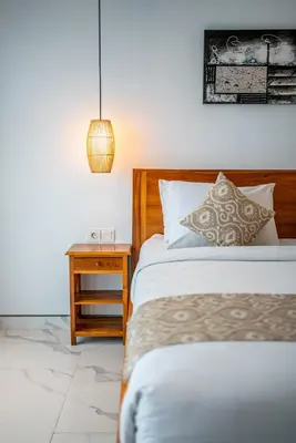 a bedroom with a bed and a night stand with a lamp at Luxury 2BR Villas in Seminyak Central in Seminyak