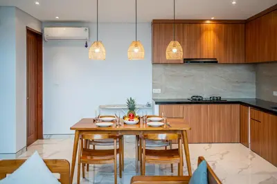 a kitchen with a wooden table and chairs at Luxury 2BR Villas in Seminyak Central in Seminyak