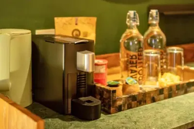 a counter with a coffee maker and two bottles of alcohol at Chaesa Comfortable 1 BR Royal Private Pool Villa in Kerobokan