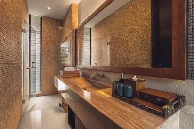 a bathroom with a sink and a large mirror at Varenya Cozy 1 BR Suite Twin Room in Kerobokan