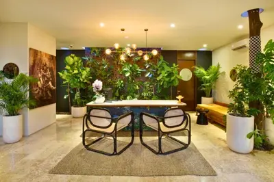 a room with a table and chairs and plants at Varenya Cozy 1 BR Suite Twin Room in Kerobokan