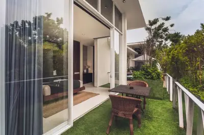 a house with a balcony with a table and chairs at Varnika Peaceful 1 BR Suite Double Room in Kerobokan