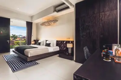 a bedroom with a king sized bed and a table at Varnika Peaceful 1 BR Suite Double Room in Kerobokan