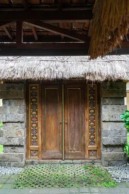 a wooden door on the side of a building at Puri Sekar Bali in Pesanggaran