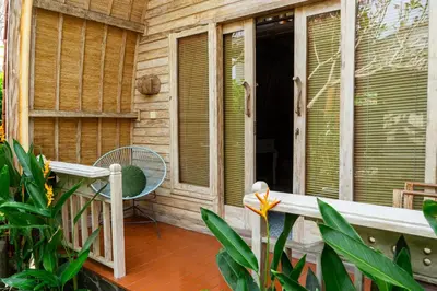 a porch with a table and a chair on a house at Puri Sekar Bali in Pesanggaran