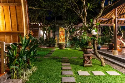 a garden with grass and plants and a pathway at Puri Sekar Bali in Pesanggaran