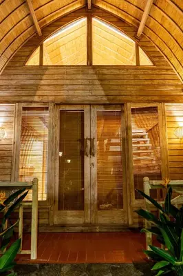 an entry to a wooden building with glass doors at Puri Sekar Bali in Pesanggaran