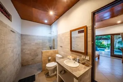 a bathroom with a toilet and a sink and a mirror at Prime Seminyak 2BR Villas in Seminyak