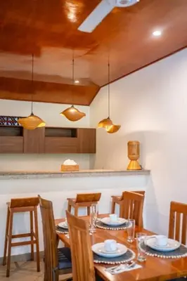 a dining room with a wooden table and chairs at Prime Seminyak 2BR Villas in Seminyak
