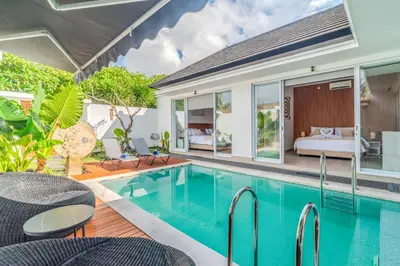 a villa with a swimming pool and a bedroom at Coastal Bliss Private 2BR Pool Villa Jimbaran in Jimbaran