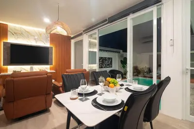 a dining room with a table and chairs and a television at Coastal Bliss Private 2BR Pool Villa Jimbaran in Jimbaran