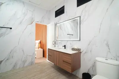 a bathroom with a white marble wall at Coastal Bliss Private 2BR Pool Villa Jimbaran in Jimbaran