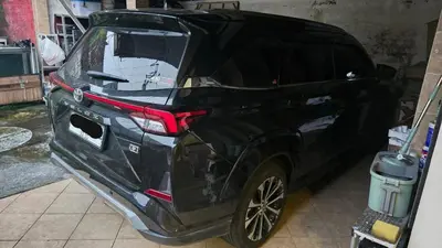 a black car parked in a garage at Mobil Veloz Q CVT in Ngurah Rai International Airport
