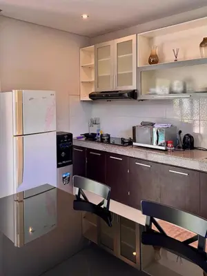 a kitchen with a refrigerator and two chairs in it at Villa Hale Mahina, Bali in Kerobokan