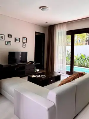 a living room with a white couch and a television at Villa Hale Mahina, Bali in Kerobokan