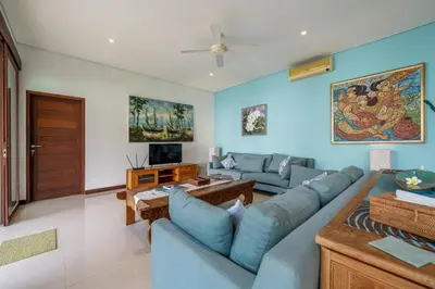 a living room with blue walls and a blue couch at Villa Samsara 3BR Pool Villa Near Berawa Beach in Canggu