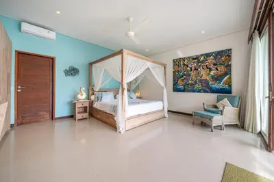 a bedroom with a bed and a painting on the wall at Villa Samsara 3BR Pool Villa Near Berawa Beach in Canggu