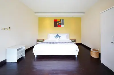 a bedroom with a white bed and a yellow wall at 6 Bedrooms Pool Twin Villa in West Sanur in Sanur