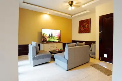 a living room with two chairs and a flat screen tv at 6 Bedrooms Pool Twin Villa in West Sanur in Sanur