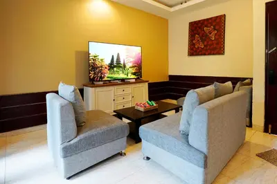 a living room with two chairs and a flat screen tv at 6 Bedrooms Pool Twin Villa in West Sanur in Sanur