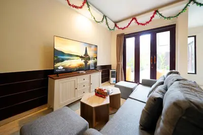 a living room with a couch and a flat screen tv at 6 Bedrooms Pool Twin Villa in West Sanur in Sanur