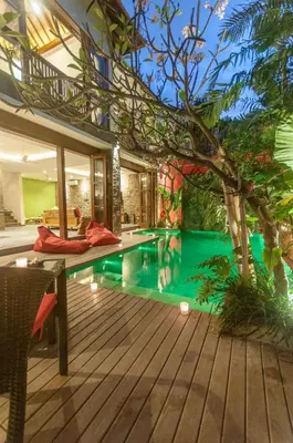 a swimming pool in a house with a wooden deck at Boutique Modern Luxury in the Heart of Seminyak in Seminyak