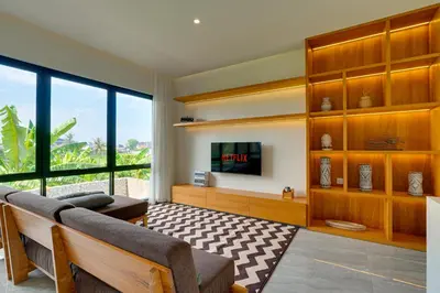 a living room with wooden furniture and a tv at Elegant Villa Vibhava 2BR in Central Umalas in Kerobokan