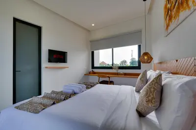 a bedroom with a large white bed and a window at Elegant Villa Vibhava 2BR in Central Umalas in Kerobokan