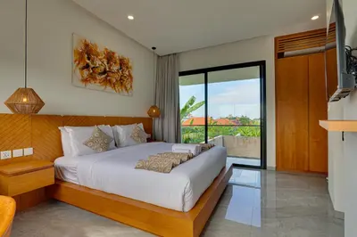 a bedroom with a large bed and a balcony at Elegant Villa Vibhava 2BR in Central Umalas in Kerobokan