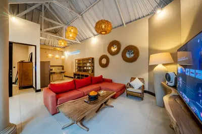 a living room with a red couch and a table at Villa Aditya Seminyak in Seminyak