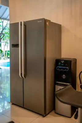 a stainless steel refrigerator next to a trash can at Villa Aditya Seminyak in Seminyak