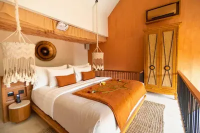 a bedroom with a large bed with orange walls at Tamasvini Romantic 1 BR Grand Private Pool Villa With Bathtub in Seminyak
