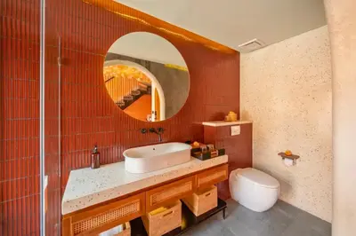 a bathroom with a sink and a mirror and a toilet at Tamasvini Romantic 1 BR Grand Private Pool Villa With Bathtub in Seminyak