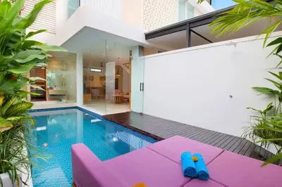 a house with a swimming pool and a pink couch at Halina Cozy 2 BR Private Pool Villa With Bathtub in Legian