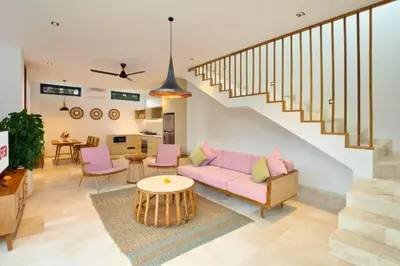 a living room with a pink couch and a staircase at Halina Cozy 2 BR Private Pool Villa With Bathtub in Legian