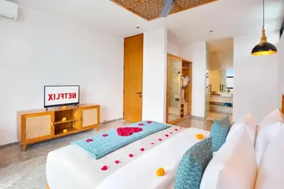 a bedroom with a large white bed and a couch at Heleina Elegant 3 BR Royal Private Pool Villa With Jacuzzi in Legian