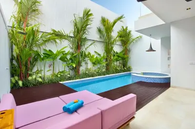 a living room with a pink couch and a swimming pool at Heleina Elegant 3 BR Royal Private Pool Villa With Jacuzzi in Legian