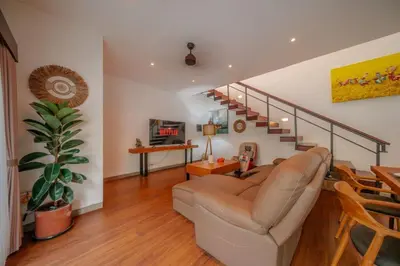 a living room with a couch and a staircase at Stunning villa in Umalas center in Canggu