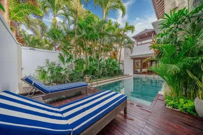 a house with a swimming pool with two lounge chairs at Stunning villa in Umalas center in Canggu