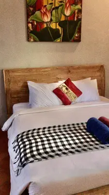 a bed with white sheets and red pillows at Kundalini Shakta Yoga Meditasi in Denpasar