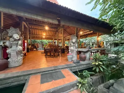 an outdoor dining area of a house with a wooden pavilion at Kundalini Shakta Yoga Meditasi in Denpasar