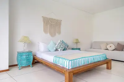 a bedroom with a bed and a couch at 2min-walk beach Atlas club,Finns Padi view in Canggu