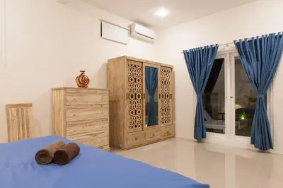 a bedroom with a blue bed and blue curtains at Cozy 2br villa at the beach in Canggu